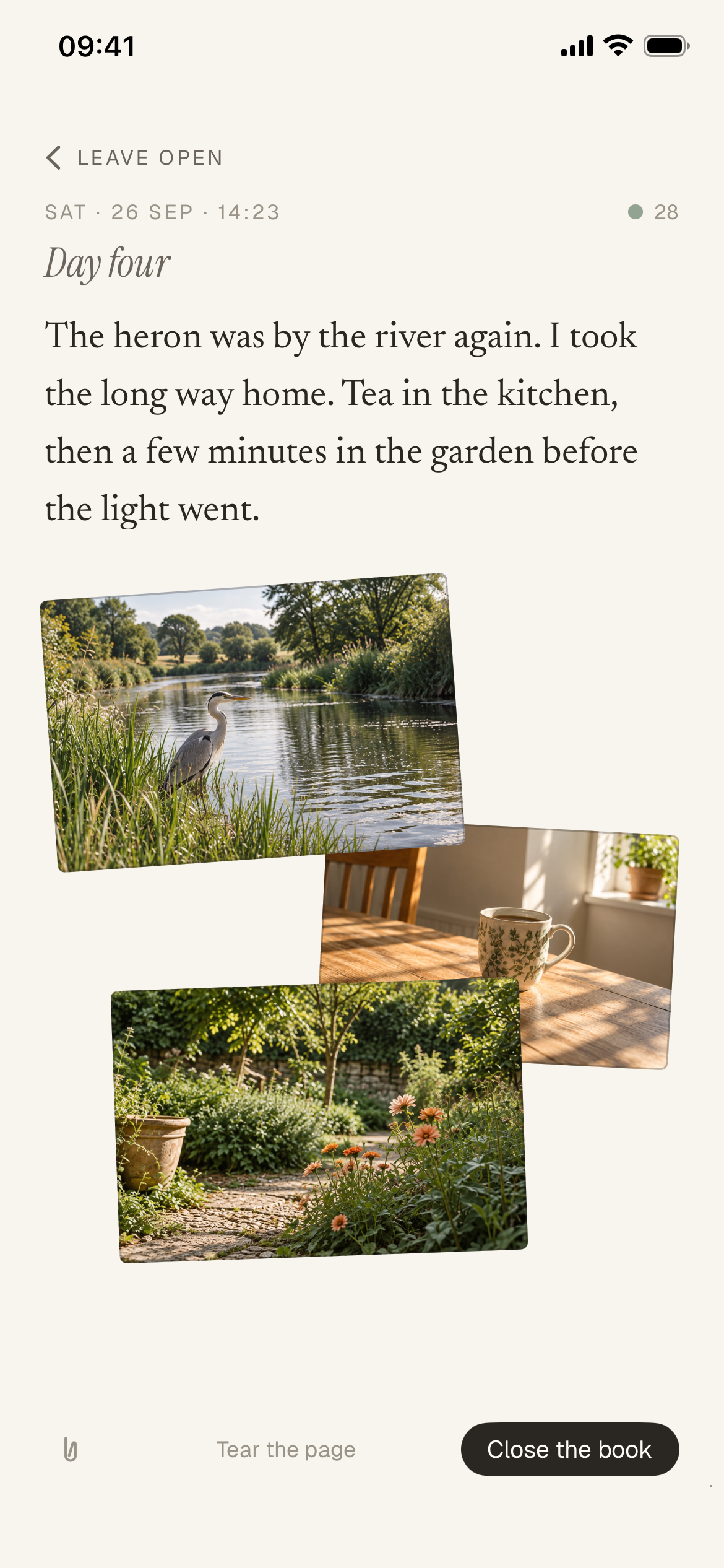 Jurnl’s writing page. At the top, Leave open, then Sat · 26 Sep · 14:23 and Day four, above the entry: “The heron was by the river again. I took the long way home. Tea in the kitchen, then a few minutes in the garden before the light went.” Below it, three photos overlap at slight angles: a heron in the reeds by a river, a patterned mug on a sunlit kitchen table, and a garden path with orange flowers. At the bottom are a paperclip button, Tear the page and Close the book.